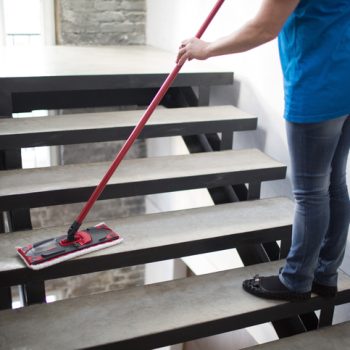 Woman washes stairway at house. Cleaning service concept. Cleaning service
